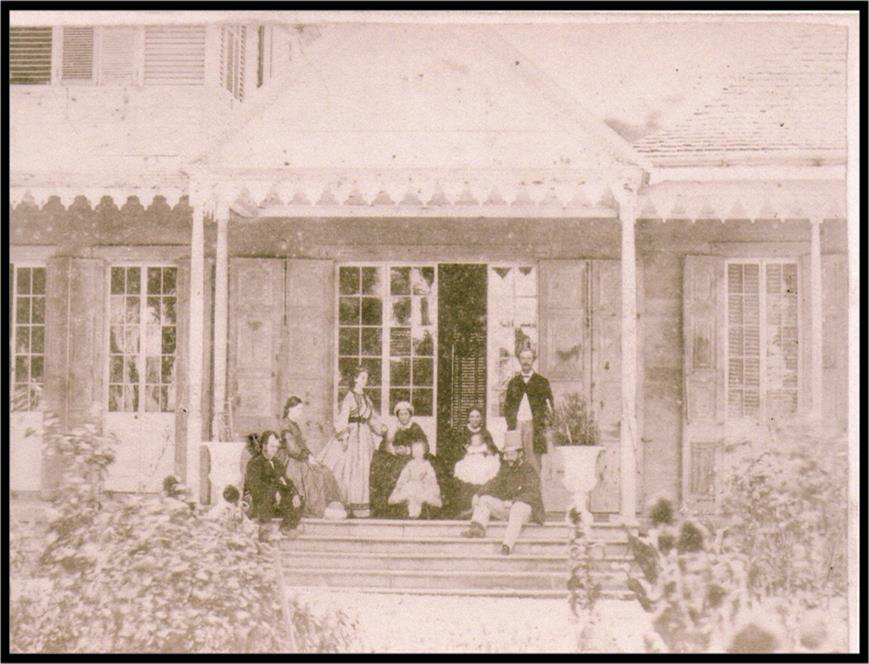This photo shows the front porch in the 1880s, with the family who lived in the house on the steps.